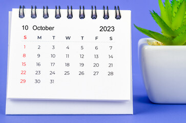 The October 2023 Monthly desk calendar for 2023 year on purple background.