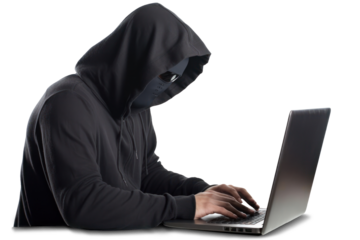 A hacker in black hoodie is working on his laptop.