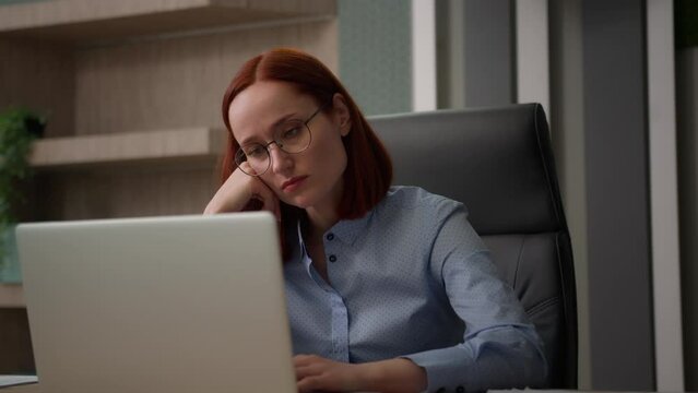 Bored sad Caucasian female girl worker tired unmotivated disinterested in online office work with laptop lazy businesswoman employee business woman lack of motivation annoyed with boredom boring job