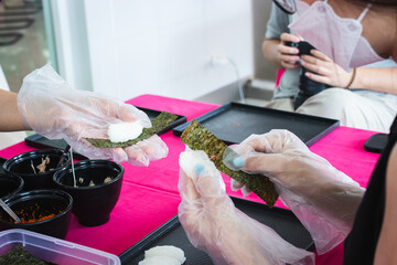 Chefs are demonstrating easy sushi making at an event.