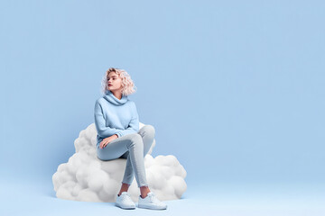 Girl sitting on the cloud with blue background - obrazy, fototapety, plakaty