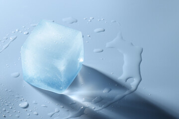 Crystal clear ice cube on light blue background, space for text