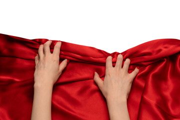 A woman's hand with red nails is trying to rip off a red silk fabric.