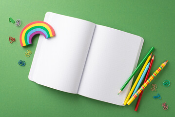 Explore joys of learning with top view. Behold playful assortment of stationery - open notepad, color pencils, number shaped clips, plasticine resting on green board backdrop with space for text or ad - Powered by Adobe