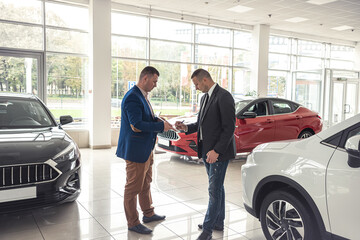 Caucasian salesman holding clipboard and talking about buying car with sale with his customer