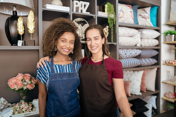 Same-sex couple poses for portrait in decoration store.