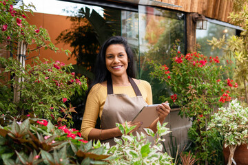 Entrepreneur poses for portrait in plant shop.