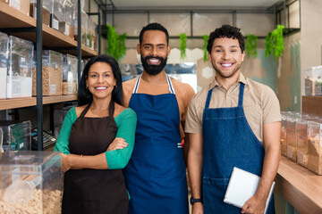 Sales team smiles for portrait in a neighborhood store.