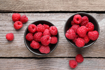 Tasty ripe raspberries on wooden table, flat lay