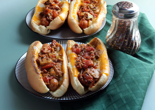 Chili dogs on cheese buns served with chili peppers for some extra heat