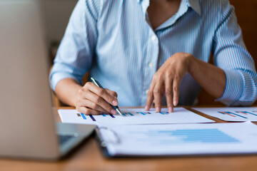 Close up of businesswoman is reading financial document and analysis about strategy of business