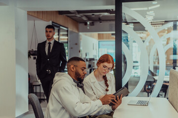 Fototapeta premium In a modern office setting, an African American businessman and his Muslim colleague, wearing a hijab, engage in collaborative discussions, tackling various business tasks and solving problems