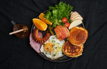 Pancakes with Fried Eggs, Sausage, Ham and Fruits