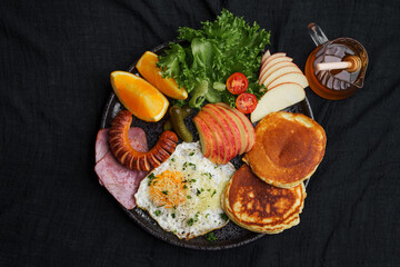 Pancakes with Fried Eggs, Sausage, Ham and Fruits