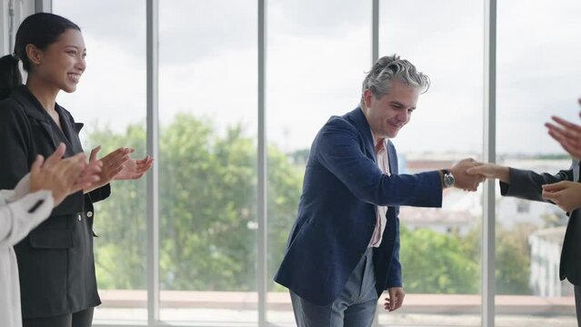 Group of business people applauding to caucasian man leader congratulation business achievement. Diverse employees clapping and shaking hands welcoming new manager. Applauding and cheering 