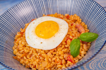 RECIPE FOR BLE WITH BACON, TOMATO AND SHALLOTS, SERVED WITH FRIED EGG. High quality photo
