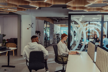 In a modern office setting, an African American businessman and his Muslim colleague, wearing a hijab, engage in collaborative discussions, tackling various business tasks and solving problems