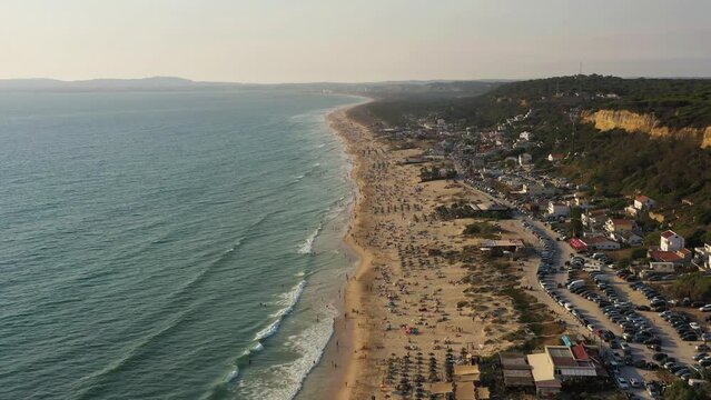 Fonte da Telha Beach and Atlantic Ocean. Portugal. Crowd of People. Aerial View. Drone Flies Forward and Upwards. Medium Shot