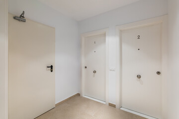 Hall space with two entrance doors to apartments or hotel rooms with the numbers one and two in white. The concept of a cozy compact five-star hotel