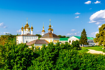 Panoramic top view of the city of Suzdal in Russia with historical architecture and a church among the lush green foliage of trees on a sunny summer day.