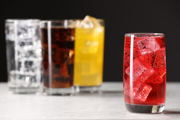 Glass of refreshing soda water with ice cubes on white table. Space for text