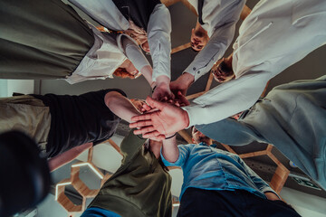 A group of young businessmen offer their hands together, symbolizing togetherness in the business world