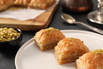 Delicious sweet baklava with pistachios on black table, closeup