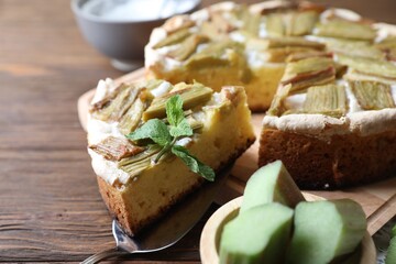 Freshly baked rhubarb pie and cake server on wooden table, closeup