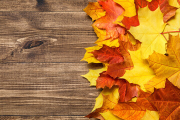 Autumn mood composition background. Frame made of autumn dried leaves on wooden background. Colorful, variegated foliage. Flat lay, top view, copy space.