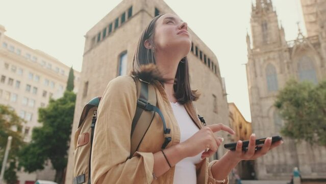 Woman using map app while standing on the square of an old european city