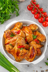 Baked chicken wings served with sweet chili sauce and fresh herbs. Selective focus.