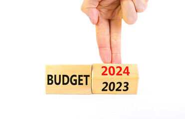 Planning 2024 budget new year symbol. Businessman turns a wooden cube and changes words Budget 2023...