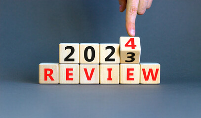2024 review new year symbol. Businessman turns a wooden cube and changes words Review 2023 to...