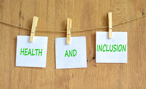 Health and inclusion symbol. Concept words Health and inclusion on beautiful white paper on clothespin. Beautiful wooden background. Business motivational health and inclusion concept. Copy space.