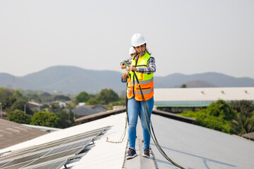 Electrician pulling wire into PVC  pipe electrical engineering female Installing Solar Cell panels on Roof. Solar energy clean and green alternative energy concept.