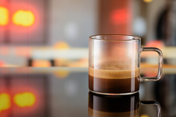 Glass cup of ristretto coffee on the bar counter with blurred background. Copy space.