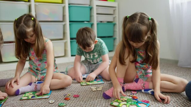 Children concentrate on putting together puzzles in primary school. Creative tasks for child development. High quality 4k footage
