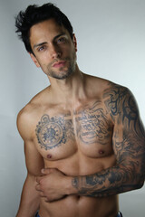 Sexy portrait of a handsome muscular topless male model on white background
