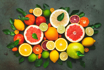 Colorful citrus fruis, food background, top view. Mix of different whole and sliced fruits: orange,...