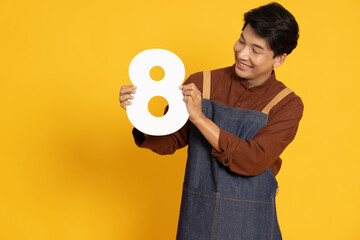 Restaurant owner sme young Asian man holding number 8 or eight isolated on yellow background