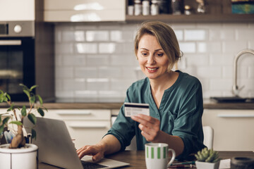 Woman Using Credit Card Online At Home