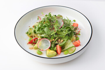 Salad of avocado, strawberries, cucumbers and lettuce leaves. Radish and avocado in salad. Useful products. Vitamin salad. Healthy food. White background.Copy space. Isolated object.