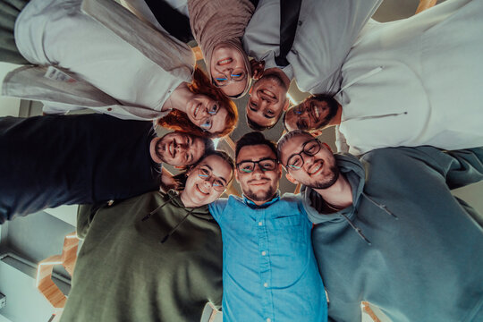 In a modern office, a group of young business professionals is captured in a warm and embracing hug, reflecting the spirit of unity, collaboration, and shared success in their dynamic workplace.