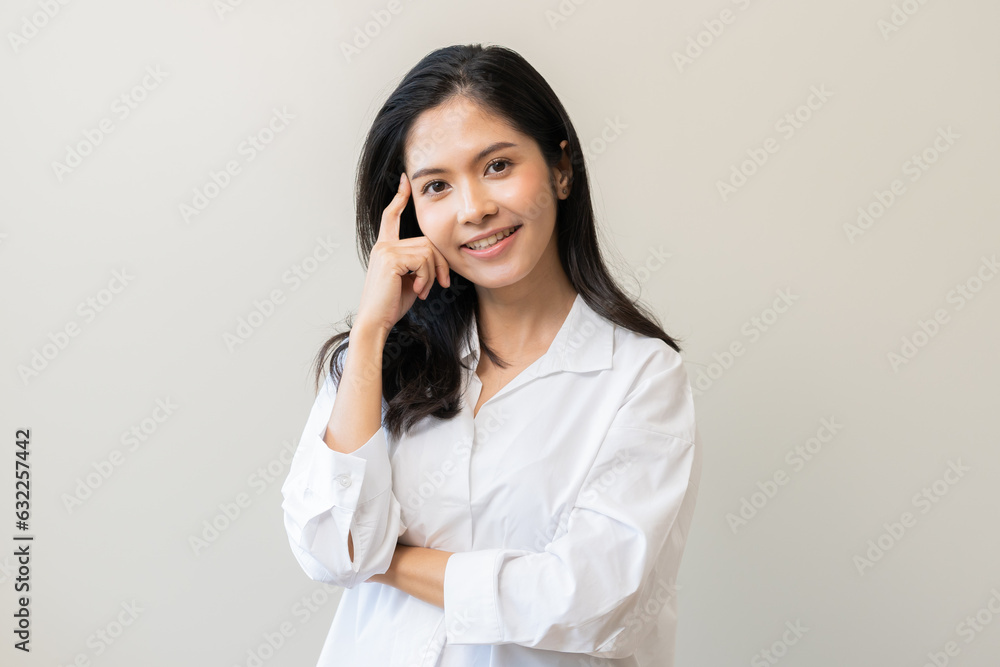 Wall mural portrait of positive thoughtful asian young woman, girl keeps hand on chin looking away in white shi