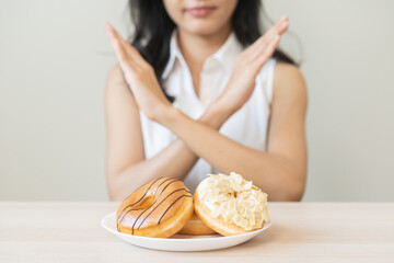 Diet concept, asian young woman hand push out, deny sugar donut, doughnut and sweet taste food on...