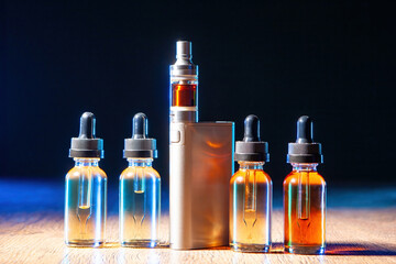 Vaper kit. Vaping oils. Vape pen. Electronic cigarette. Divas for vapers on wooden table. Vaping...