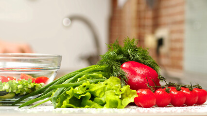 Salt the vegetables salad slow motion. Making vegetable salad outdoors. Cooking salad from fresh raw vegetables - tomatoes, cucumbers, greens, pepper, scallion, onion, olive oil. Outdoors