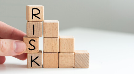 Financial risk assessment, risk reward and portfolio risk management concept. Blocks of wood cubes arranged creatively to depict the concept. Letters R, I, S, K on cubes.
