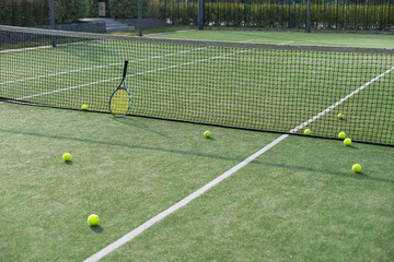 Tennis court Top view Six tennis balls and racket on the green grass background