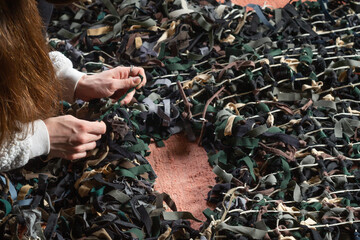 Weaving of camouflage nets made of fabric. Russian-Ukrainian war